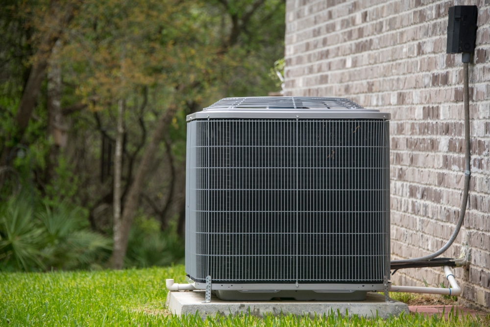A picture of a broken air conditioner that needs repair along a wall of a home in Orlando Florida.