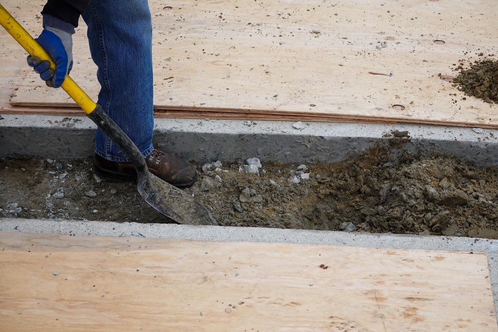 Leg,Of,Laborer,With,Shovel,Digging,A,Ditch,Through,A
