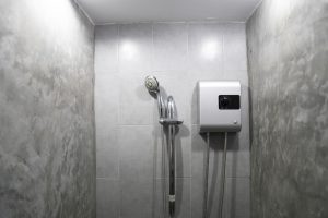 tankless water heater installed on grey tile wall